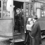 hombres con mascarilla subiendo a un tranvía